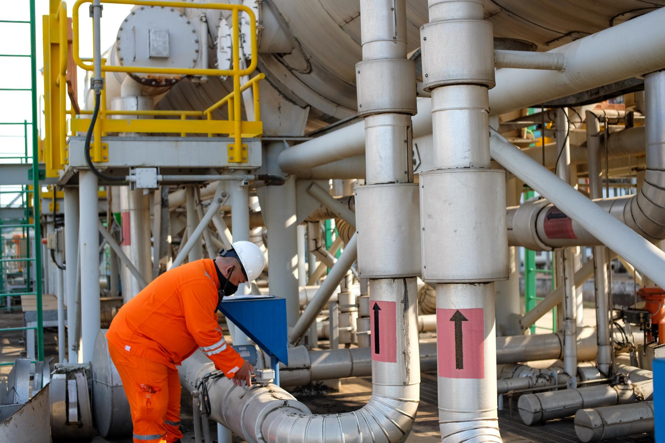 Industrial worker inspecting water desalination oil and gas refinery pipelines