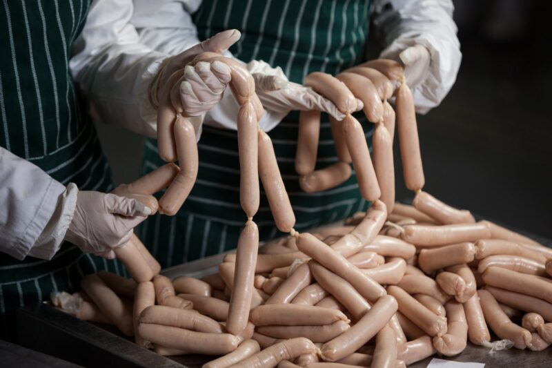 Workers Preparing Sausage in Factory