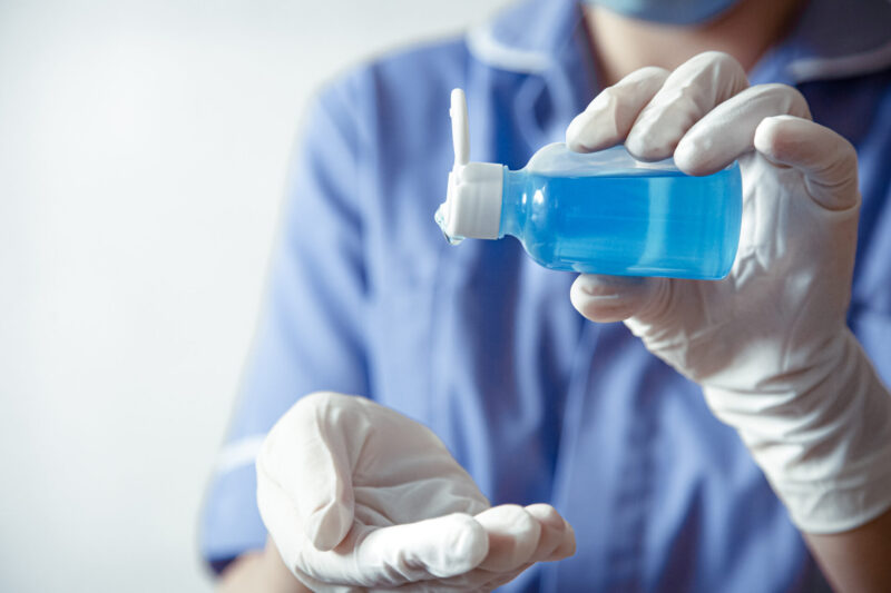 The doctor in white gloves uses hand sanitizer against the spread of the Corona covid 19 virus.